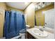 Bright bathroom with a blue patterned shower curtain, vanity, and functional toilet for everyday living at 6403 Heritage Run, Morrow, GA 30260