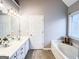 Bright bathroom with a double vanity, soaking tub, and a large window at 329 Royal Crescent Way, Stockbridge, GA 30281