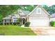 Attractive home with manicured lawn, mature trees, and attached garage at 329 Royal Crescent Way, Stockbridge, GA 30281