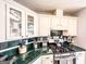 Close up view of kitchen featuring white cabinets, green tile countertops, and stainless steel gas range at 329 Royal Crescent Way, Stockbridge, GA 30281