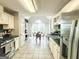 Eat-in kitchen features white cabinets, stainless steel appliances, tiled floors, and a large window at 329 Royal Crescent Way, Stockbridge, GA 30281
