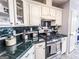 Kitchen features white cabinets, green tile countertops, and a stainless steel gas range at 329 Royal Crescent Way, Stockbridge, GA 30281