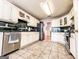 Light filled eat-in kitchen with white cabinets, tile countertops, stainless steel appliances, and tile floors at 329 Royal Crescent Way, Stockbridge, GA 30281