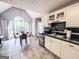 Bright eat-in kitchen with white cabinets, tile floors, and large window overlooking outdoor seating at 329 Royal Crescent Way, Stockbridge, GA 30281