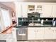 Traditional white kitchen cabinets, green backsplash, with view to the fireplace in this cozy home at 329 Royal Crescent Way, Stockbridge, GA 30281