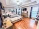 Main bedroom featuring a tray ceiling, artwork, and hardwood floors at 329 Royal Crescent Way, Stockbridge, GA 30281