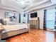 Spacious main bedroom with tray ceiling, hardwood floors, dresser, and modern decor at 329 Royal Crescent Way, Stockbridge, GA 30281