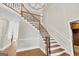 Elegant staircase featuring hardwood steps, wrought iron railings, and a decorative chandelier at 513 Viridian Vw, Peachtree City, GA 30269