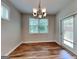 Well-lit dining room featuring wood flooring, a modern chandelier, and a door leading to the backyard at 471 Lanier Ct, Hiram, GA 30141