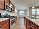 Modern kitchen featuring stainless steel appliances, wooden cabinets, granite countertops, and wood flooring at 471 Lanier Ct, Hiram, GA 30141