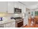 Bright kitchen displays stainless steel range, white cabinets, subway tile backsplash, and marble countertops at 412 Rock Creek Dr, Peachtree City, GA 30269