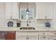 Updated kitchen featuring stainless steel dishwasher, marble countertops, and white cabinets and fixtures at 412 Rock Creek Dr, Peachtree City, GA 30269