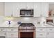 Gourmet kitchen with stainless steel appliances, gas range, white cabinets and marble countertops at 412 Rock Creek Dr, Peachtree City, GA 30269