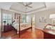 Spacious primary bedroom with trey ceiling, floral bedding, hardwood floors and ensuite bathroom access at 412 Rock Creek Dr, Peachtree City, GA 30269