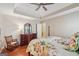 Comfortable primary bedroom features a trey ceiling, dresser, rocking chair, and wood floors at 412 Rock Creek Dr, Peachtree City, GA 30269