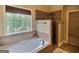 Bright bathroom featuring a soaking tub with a window and a tiled walk-in shower at 137 Nobility Ln, Mcdonough, GA 30252