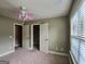 Bedroom with pink fan, plush carpet, open closet door, and window at 137 Nobility Ln, Mcdonough, GA 30252