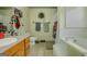 Bright bathroom with a vanity and a soaking tub surrounded by white tile, perfect for relaxation at 1170 Peeksville Rd, Locust Grove, GA 30248