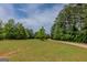 Expansive green lawn and gravel driveway create a welcoming entrance to this beautiful property at 1170 Peeksville Rd, Locust Grove, GA 30248
