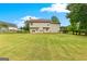 Spacious backyard with lawn featuring a two-story house with a chimney and wooden fence at 355 Sturgess Run, Sharpsburg, GA 30277
