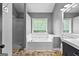 Well-lit bathroom showcasing a bathtub, large window, and neutral color palette at 355 Sturgess Run, Sharpsburg, GA 30277
