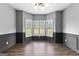 Formal dining room featuring wood-look flooring, wainscoting, crown molding, and natural light from three windows at 355 Sturgess Run, Sharpsburg, GA 30277