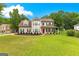 Charming two-story home with a manicured lawn and a welcoming front porch and a bright red front door at 355 Sturgess Run, Sharpsburg, GA 30277