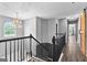 Upstairs landing featuring wood-look floors, modern chandelier and staircase with dark wood bannister at 355 Sturgess Run, Sharpsburg, GA 30277