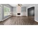 Inviting living room featuring a fireplace, wood-look flooring, a ceiling fan and natural light from the windows at 355 Sturgess Run, Sharpsburg, GA 30277