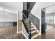 Foyer with stairs featuring a black handrail, and wood trim on a decorative accent wall at 355 Sturgess Run, Sharpsburg, GA 30277