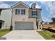 Charming two-story home featuring a gray garage door and light brick facade on a sunny day at 13 Butternut Way # 120B, Auburn, GA 30011