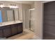 Bathroom featuring a double vanity, framed mirror, and shower with glass doors at 42 Avian Way # 128B, Auburn, GA 30011