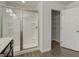 Bathroom featuring glass shower, tiled walls, and an adjacent shelving space at 42 Avian Way # 128B, Auburn, GA 30011