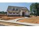Home's exterior featuring a covered front porch, sidewalk, stone accents, and manicured lawn at 42 Avian Way # 128B, Auburn, GA 30011