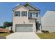New two-story home with a two car garage, brick, siding, and professionally landscaped front yard at 42 Avian Way # 128B, Auburn, GA 30011