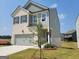 New two-story home with a two car garage, brick, siding, and newly installed landscaping at 42 Avian Way # 128B, Auburn, GA 30011