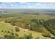 Beautiful aerial shot showing property's size, road access, fenced pasture, and natural wooded surroundings at 99 Landers Ne Rd, Rydal, GA 30171