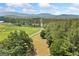 Expansive aerial view of the property showcasing the lush greenery, tree line and access road at 99 Landers Ne Rd, Rydal, GA 30171