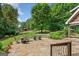 Inviting stone patio with outdoor seating, overlooks a lush backyard and barn at 99 Landers Ne Rd, Rydal, GA 30171