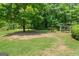 The lush backyard features mature trees, open green space, and shaded wooded area at 99 Landers Ne Rd, Rydal, GA 30171