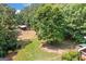 Large backyard with lush trees, open lawn and outbuilding with fenced pasture at 99 Landers Ne Rd, Rydal, GA 30171