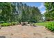 A spacious stone patio has seating and overlooks the expansive backyard with wooded area and barn at 99 Landers Ne Rd, Rydal, GA 30171