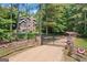 Charming home exterior with stone accents, a well-manicured lawn, and a decorative gate entrance at 99 Landers Ne Rd, Rydal, GA 30171