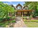 Charming home exterior with stone pathway, covered porch, and inviting landscaping at 99 Landers Ne Rd, Rydal, GA 30171