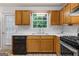 Galley kitchen featuring wooden cabinets, stainless steel appliances, and a bright window view at 520 Lakecourt Dr, Mcdonough, GA 30253