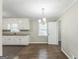 Open dining area with white cabinets, hardwood floors, a modern chandelier and natural light at 195 Southmoor Cir, Stockbridge, GA 30281