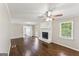 Spacious living room featuring wood floors, a brick fireplace, and ample natural light from the window at 195 Southmoor Cir, Stockbridge, GA 30281