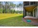 Expansive backyard featuring lush green lawn and mature trees, with a glimpse of the home's covered patio at 100 Regina Ct, Fayetteville, GA 30215