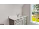 Bathroom vanity with light gray cabinetry, quartz countertop, chrome faucet, and a window with natural light at 100 Regina Ct, Fayetteville, GA 30215