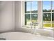 Close up of the chrome faucet hardware on a soaking tub next to a bright window at 100 Regina Ct, Fayetteville, GA 30215
